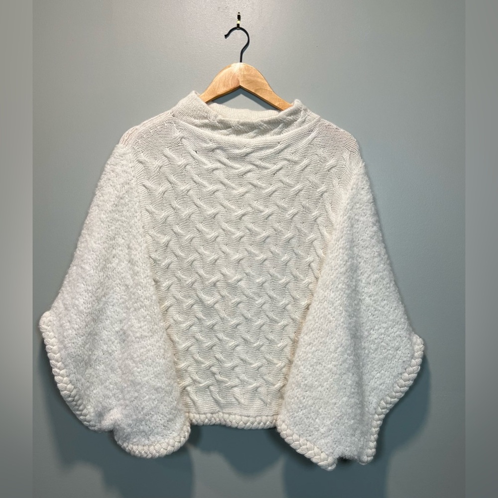 Shupaca Cape/Poncho in Cream White. Cable Knit Torso trimmed in braiding